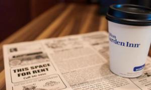 Coffee News. A cup of coffee marked Hilton Garden Inn, on top of a newspaper.