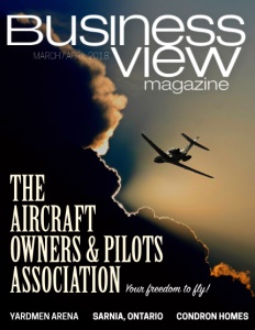 Business View Magazine March 2018 cover showing a jet flying through the sky with dark clouds and sunlight visible.