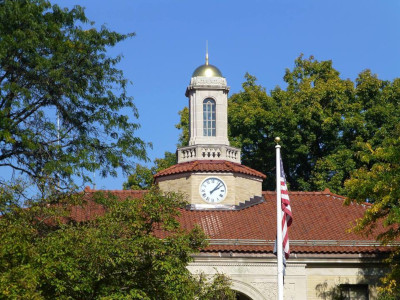Glen Ridge Borough front of the municipal complex with a tower and clock on the roof and American flag out front.