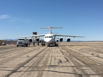 A jet airplane on the tarmac of Pueblo Memorial Airport, with the control tower in the back left.